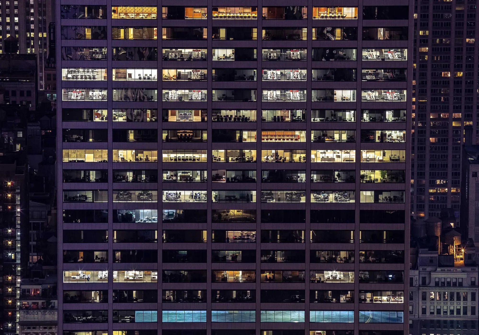 Nächtliche Fassade eines Bürogebäudes mit beleuchteten Fenstern